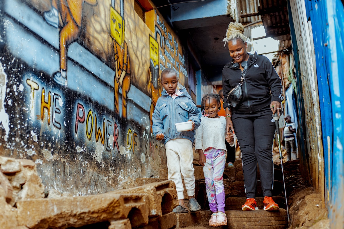 An adult walking alongside two children