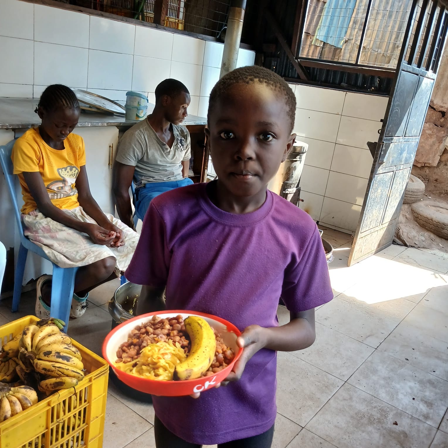 A child holding a meal in Palo’s Kitchen